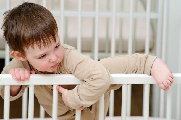 toddler climbing out of their cot